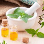 pestle and mortar with fresh herbs and oils