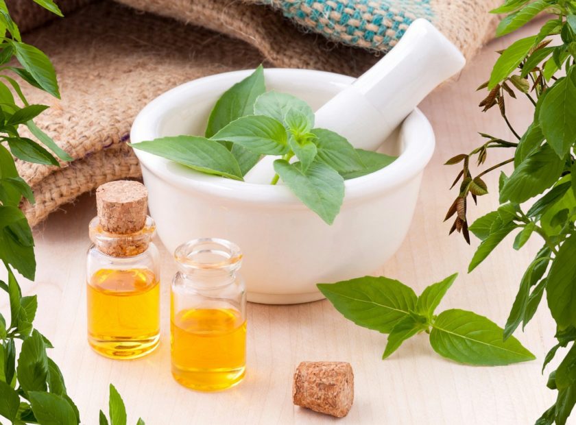 pestle and mortar with fresh herbs and oils