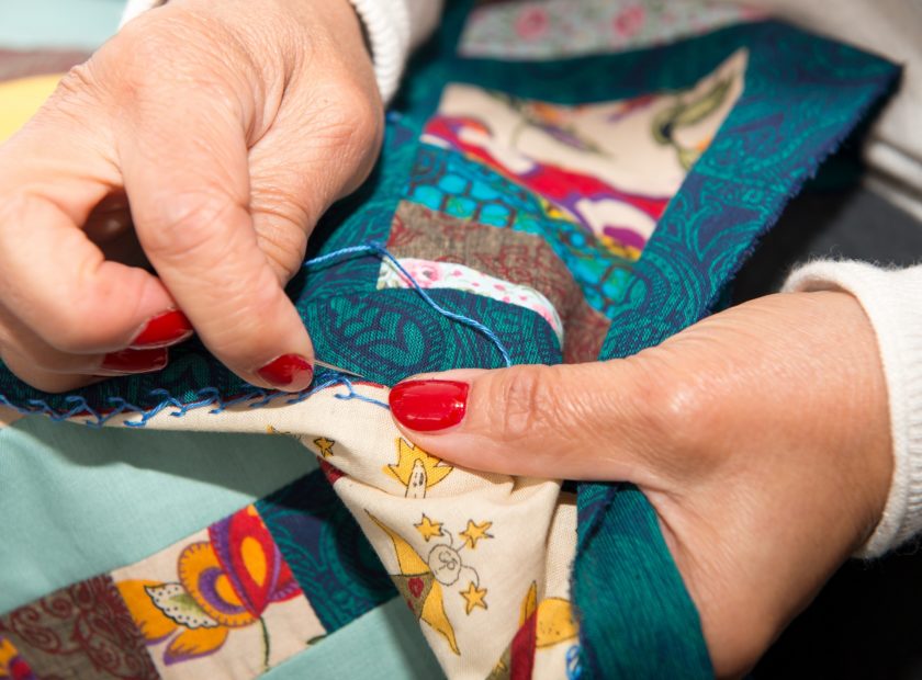 seamstress woman sewing for finish a quilt.